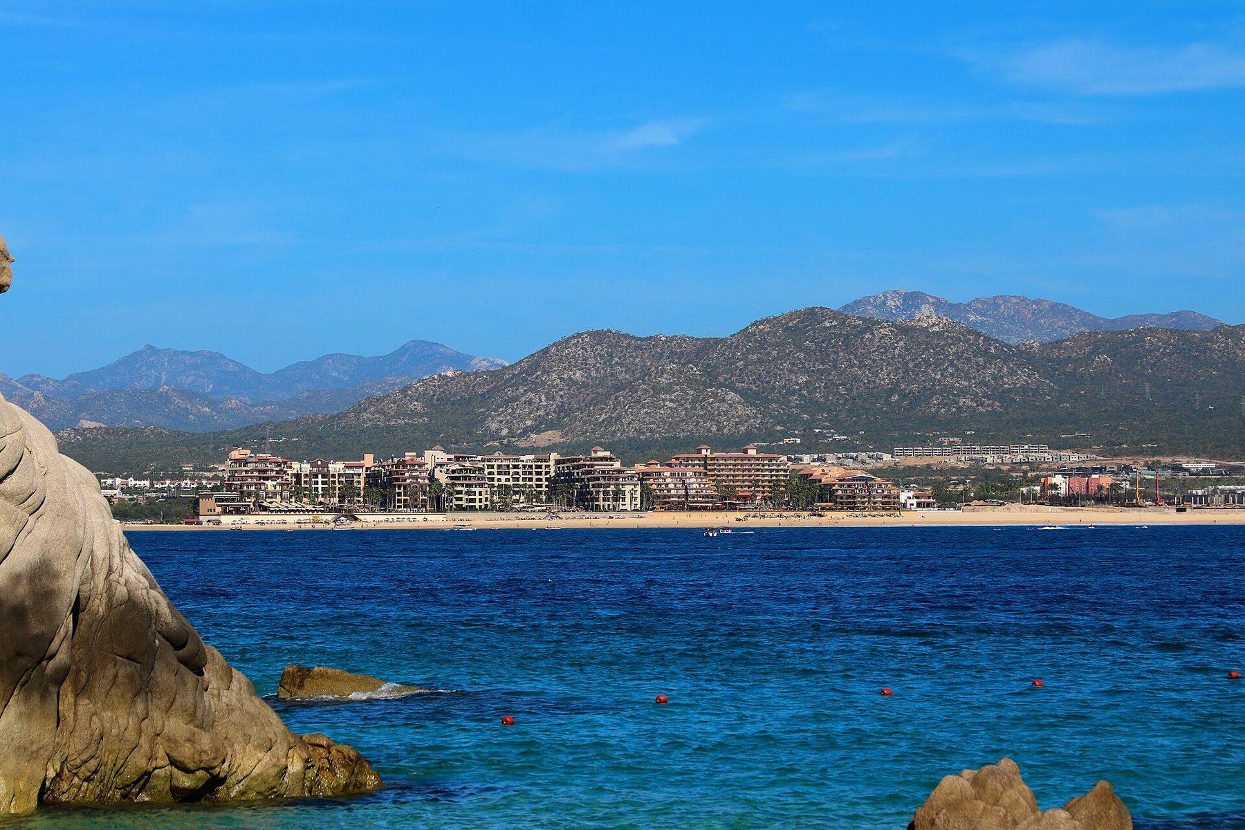 Medano Beach in Cabo San Lucas with water sports activities and beachfront restaurants